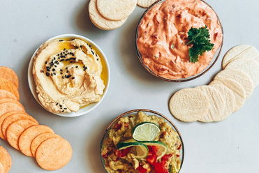 Drei vegane Dips mit Reis Crackern: Hummus, Paprika Dip & Guacamole